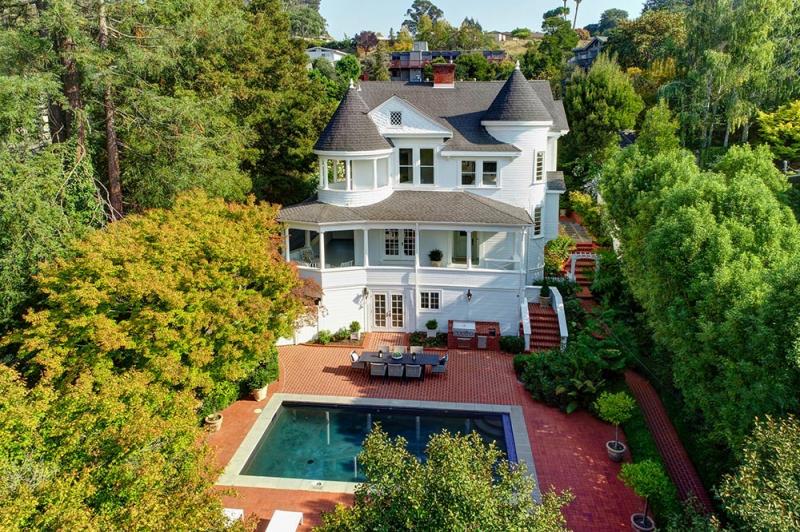 130 Palm Avenue Exterior View White Victorian Style House in wooded area with rectangle swimming pool in foreground